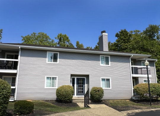 a white house with a blue sky behind it at Deercross Apartments, Cincinnati, OH 45236