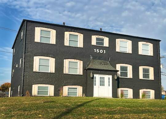 a black building with a white door on a hill
