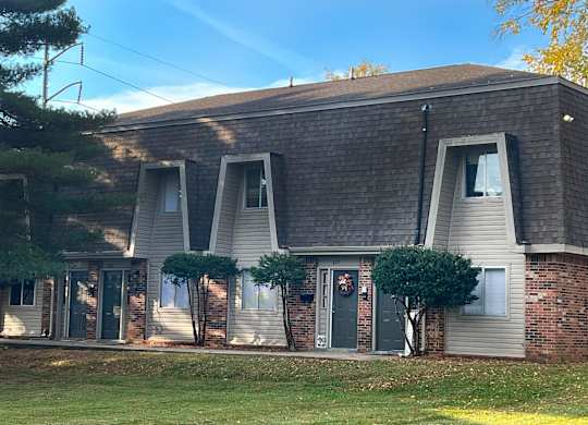 the front of a house with three windows and a door