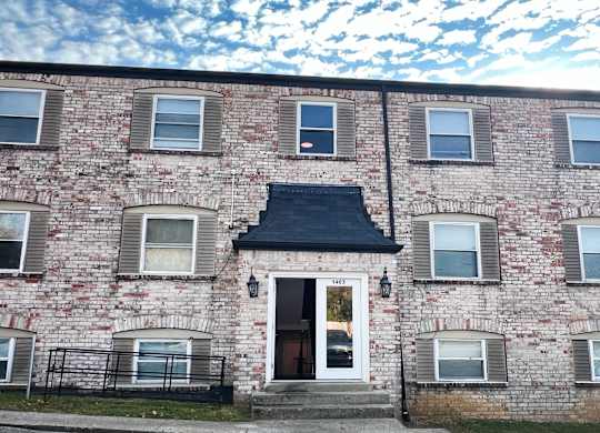 the front of a brick building with a white door