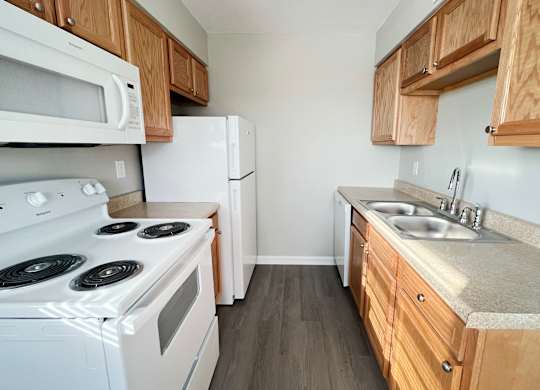 an empty kitchen with a stove refrigerator and sink
