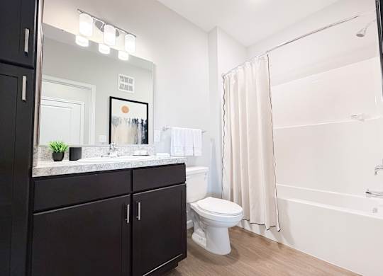 A bathroom with a toilet, sink, and bathtub.