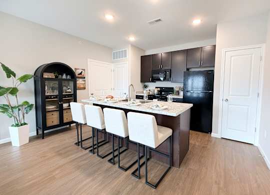 A kitchen with a table and chairs in the middle of the room.