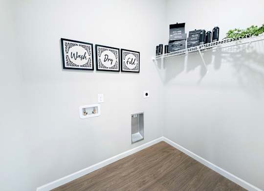 A bathroom with a shelf and three signs on the wall.