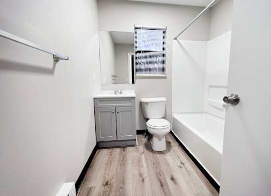 A white bathroom with a toilet, sink, and bathtub.