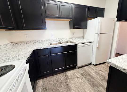 an empty kitchen with white appliances and black cabinets at Indian Lookout Apartments, Cincinnati, 45238