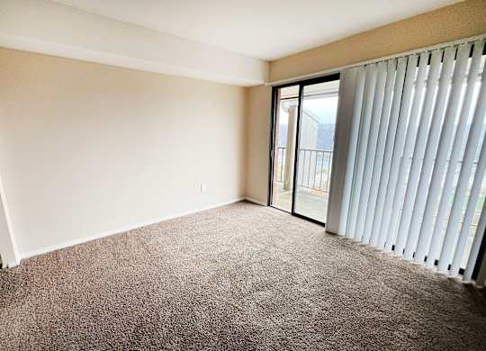 A room with a carpeted floor and sliding glass doors at Indian Lookout Apartments, Cincinnati