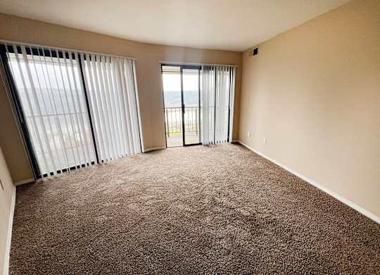 an empty living room with sliding glass doors to a balcony  at Indian Lookout Apartments, Cincinnati, 45238