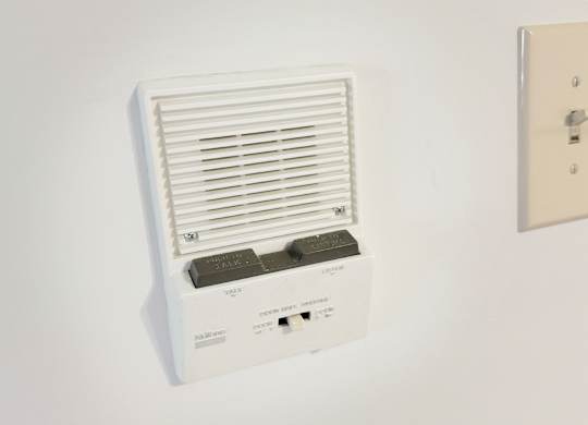 A wall-mounted air conditioner unit with a remote control.