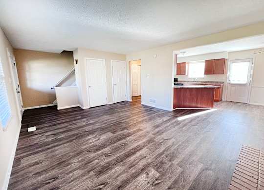 A room with wooden flooring and white walls.