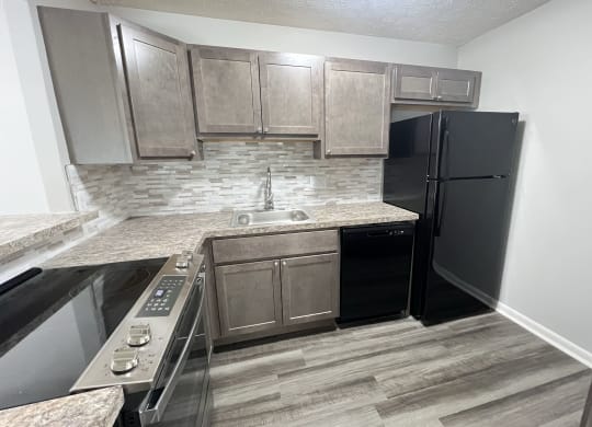 a kitchen with stainless steel appliances and wooden cabinets at Fox Run Apartments, Cincinnati