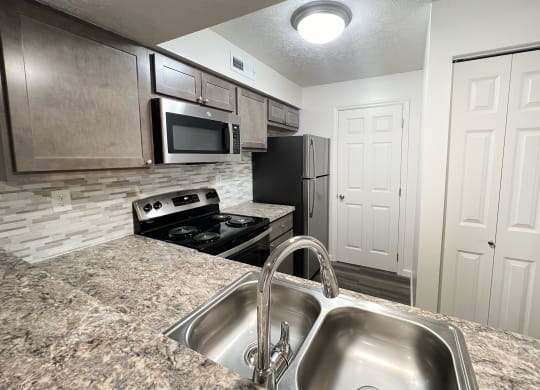 a kitchen with stainless steel appliances and granite counter tops at Deercross Apartments, Ohio