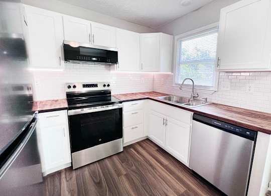 A kitchen with white cabinets and stainless steel appliances.