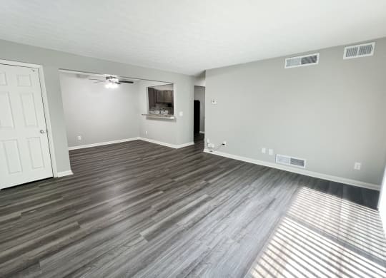an empty living room with wood flooring and a white door at Fox Run Apartments, Cincinnati