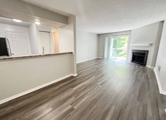 an empty living room with wood flooring and a fireplace at Deercross Apartments, Ohio, 45236