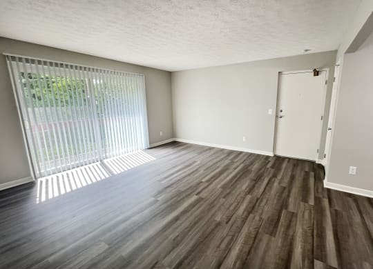 an empty living room with wood flooring and a window at Fox Run Apartments, Cincinnati