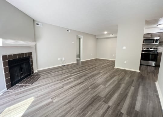 a living room with a fireplace and wooden floors at Deercross Apartments, Cincinnati, OH 45236