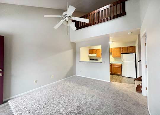 A room with a ceiling fan and a carpeted floor.