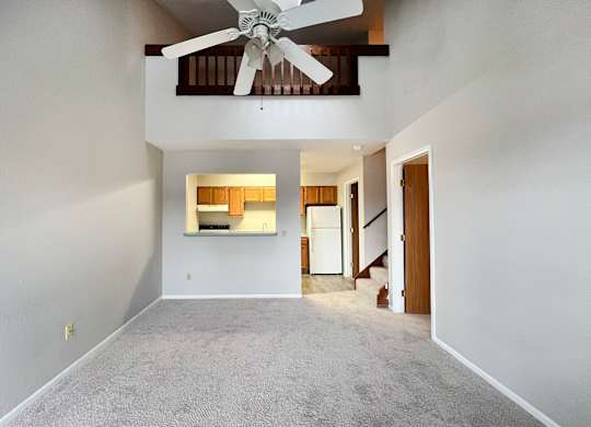 A room with a ceiling fan and a window with blinds.