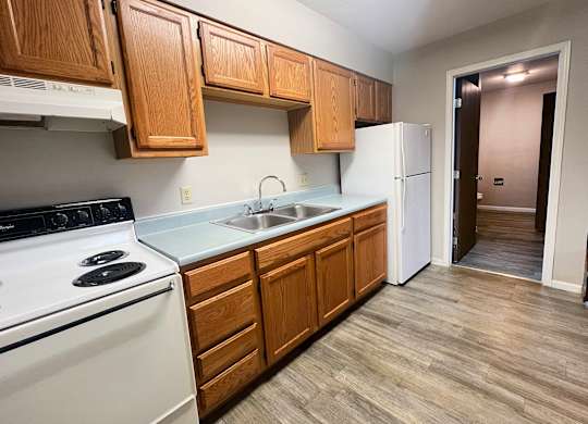 A kitchen with wooden cabinets and a white stove.