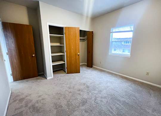 A room with a carpeted floor and a window.