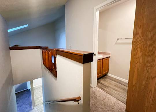 A room with a white wall and a wooden door.