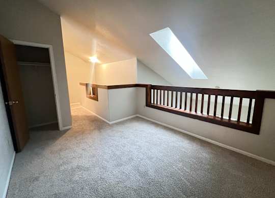 A room with a carpeted floor and a skylight.