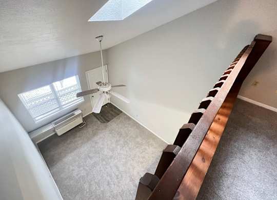 A room with a skylight and a fan.