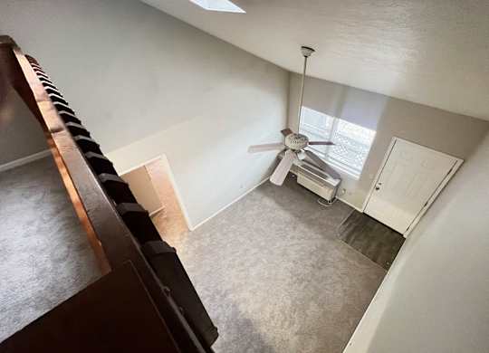 A room with a ceiling fan and a door.
