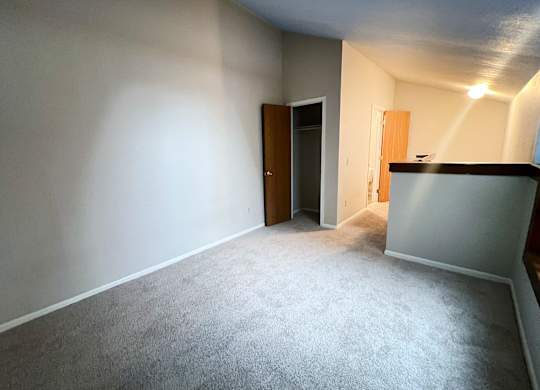 A room with a carpeted floor and two doors.