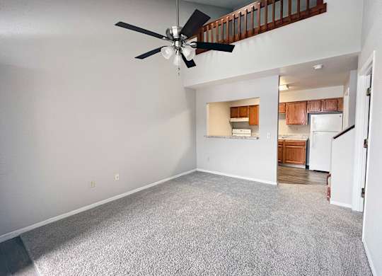 A room with a ceiling fan and a carpeted floor.