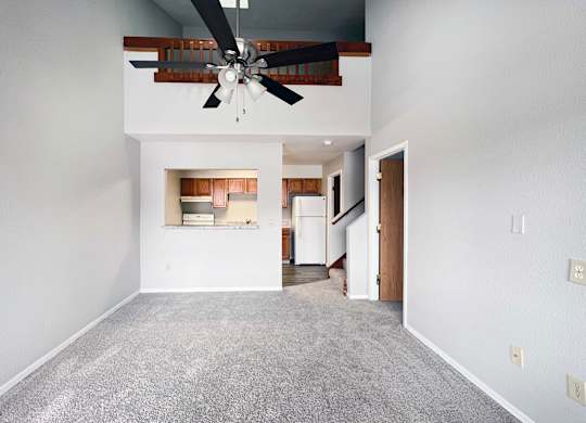 A room with a ceiling fan and a carpeted floor.