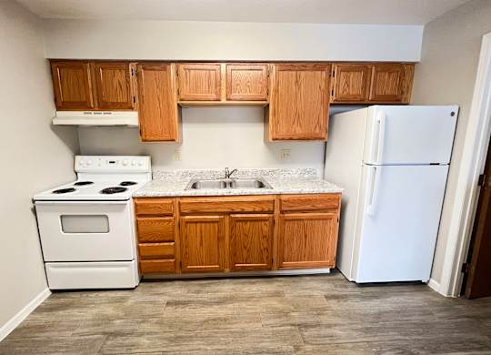 A kitchen with wooden cabinets and a white refrigerator.