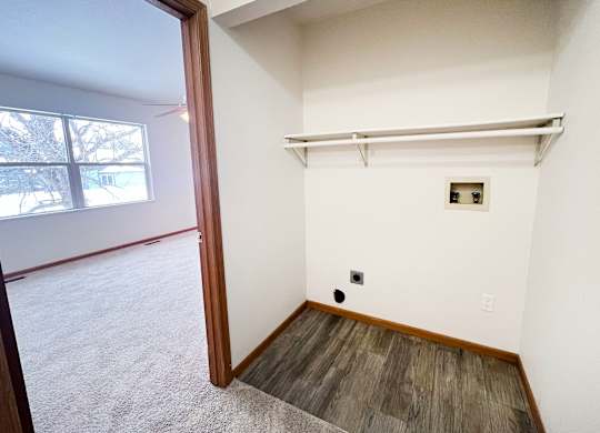 A room with a white wall and a small window.