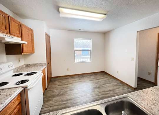 A kitchen with a stove top oven and a sink.