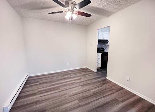 A room with a ceiling fan and wooden flooring.