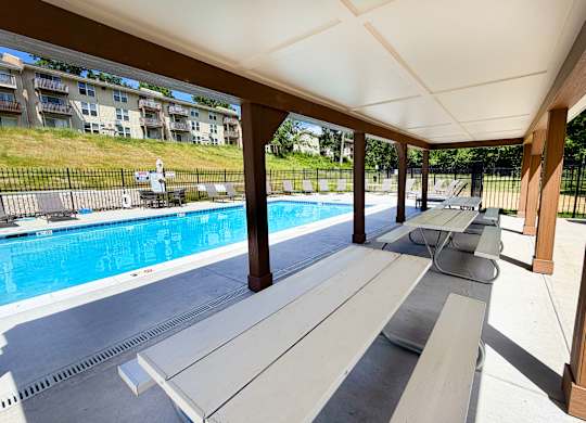 A pool area with a bench and a pool.