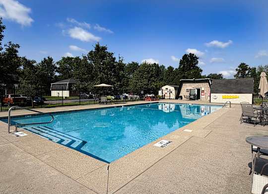 A large outdoor swimming pool with a blue tiled edge and a white line in the middle.