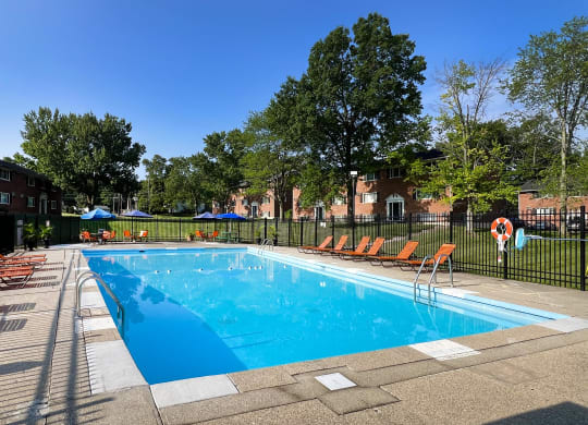 a swimming pool with chairs around it in front of a building at Sharondale Woods Apartments, Cincinnati, 45241