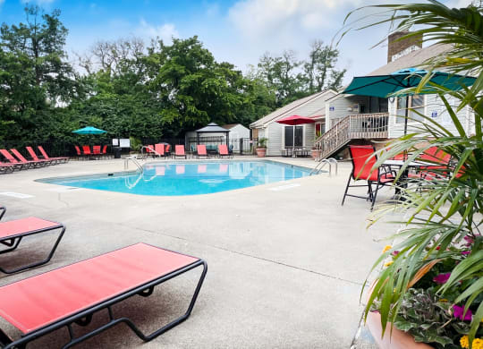 a swimming pool with red chaise lounge chairs and umbrellas  at Hunter's Creek Apartments, Ohio, 45242