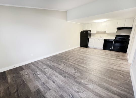 an empty living room with wood flooring and a kitchen  at Wentworth Estates Apartments, Florence, Kentucky