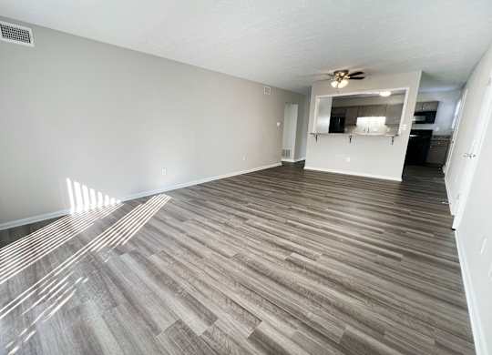 A room with wooden flooring and a ceiling fan.