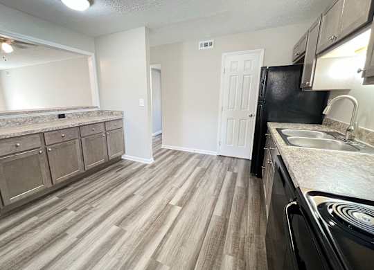 A kitchen with a black fridge and a sink at Revere Village Apartments, Ohio, 45458