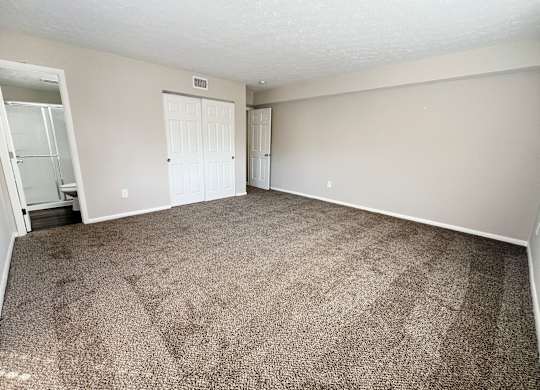 an empty living room with carpeting and white walls at Revere Village Apartments, Centerville