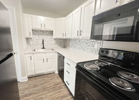 a kitchen with black appliances and white cabinets at 450 on Keeneland Apartments, Kentucky
