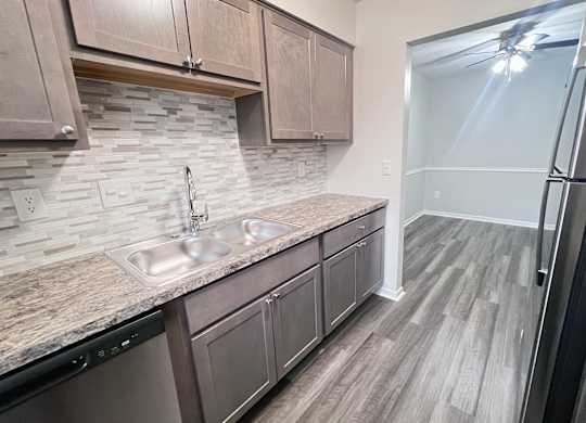 A kitchen with a sink and a refrigerator.