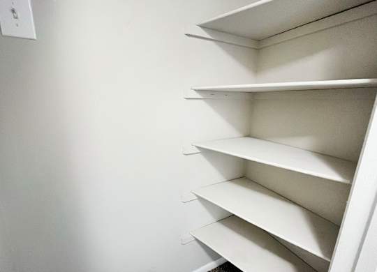 a small closet with white shelves and a white wall at Revere Village Apartments, Centerville, Ohio