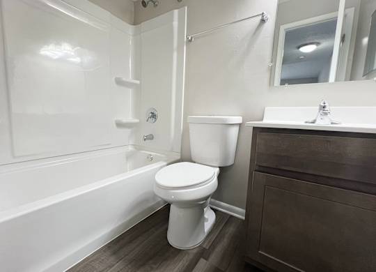 a bathroom with a toilet and a tub and a sink at Revere Village Apartments, Centerville