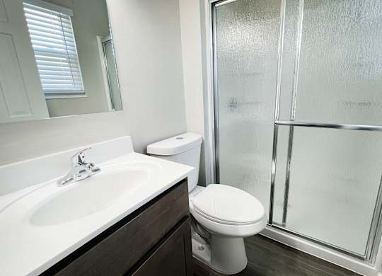 an empty bathroom with a shower toilet and sink at Revere Village Apartments, Centerville, OH, 45458