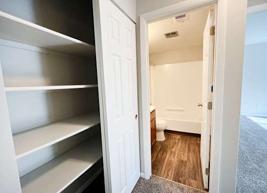 A white door is open to a small bathroom.